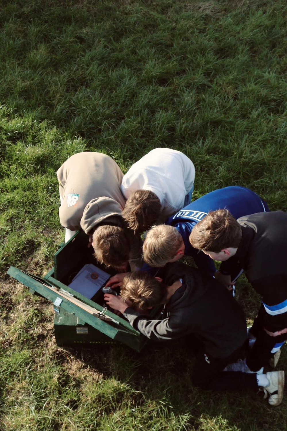 Groep rond de open escapebox in het gras