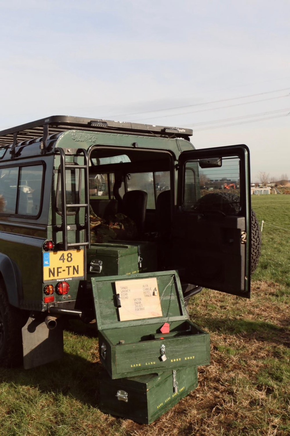 Land Rover Defender met open achterklep in het veld