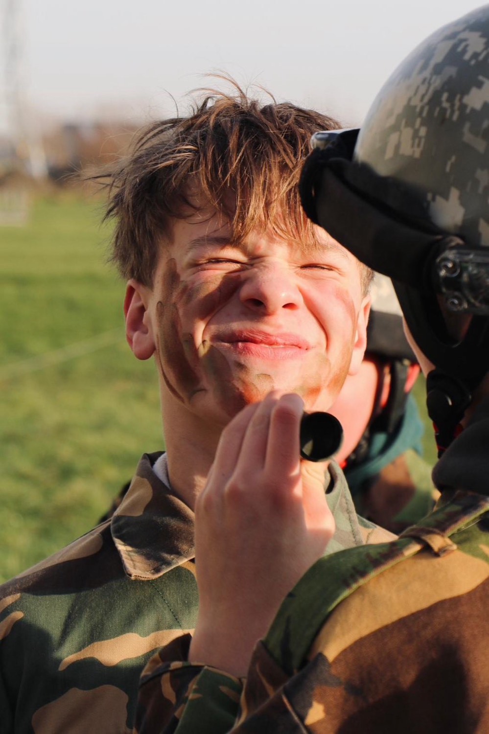Deelnemer met camouflageverf op het gezicht