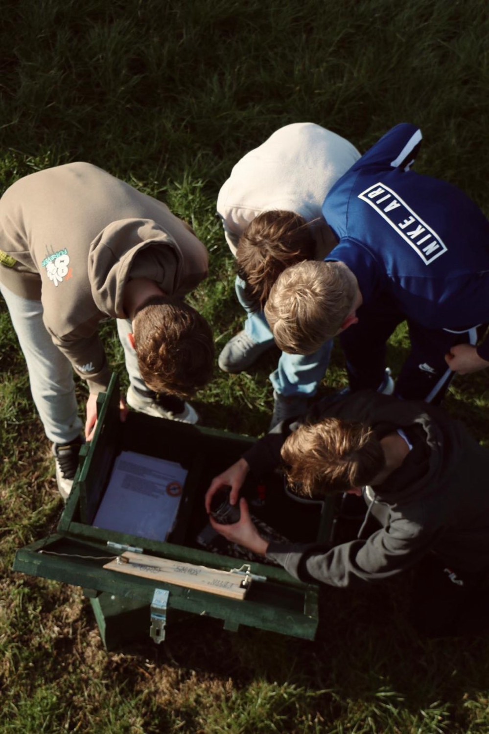 Groep rond de escapebox in het gras
