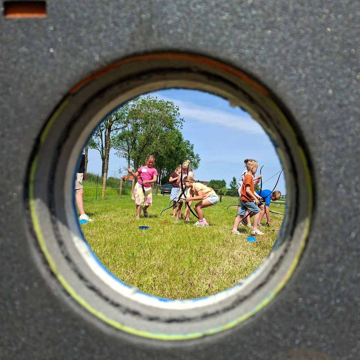 Groep in het veld gezien door een kijkgat