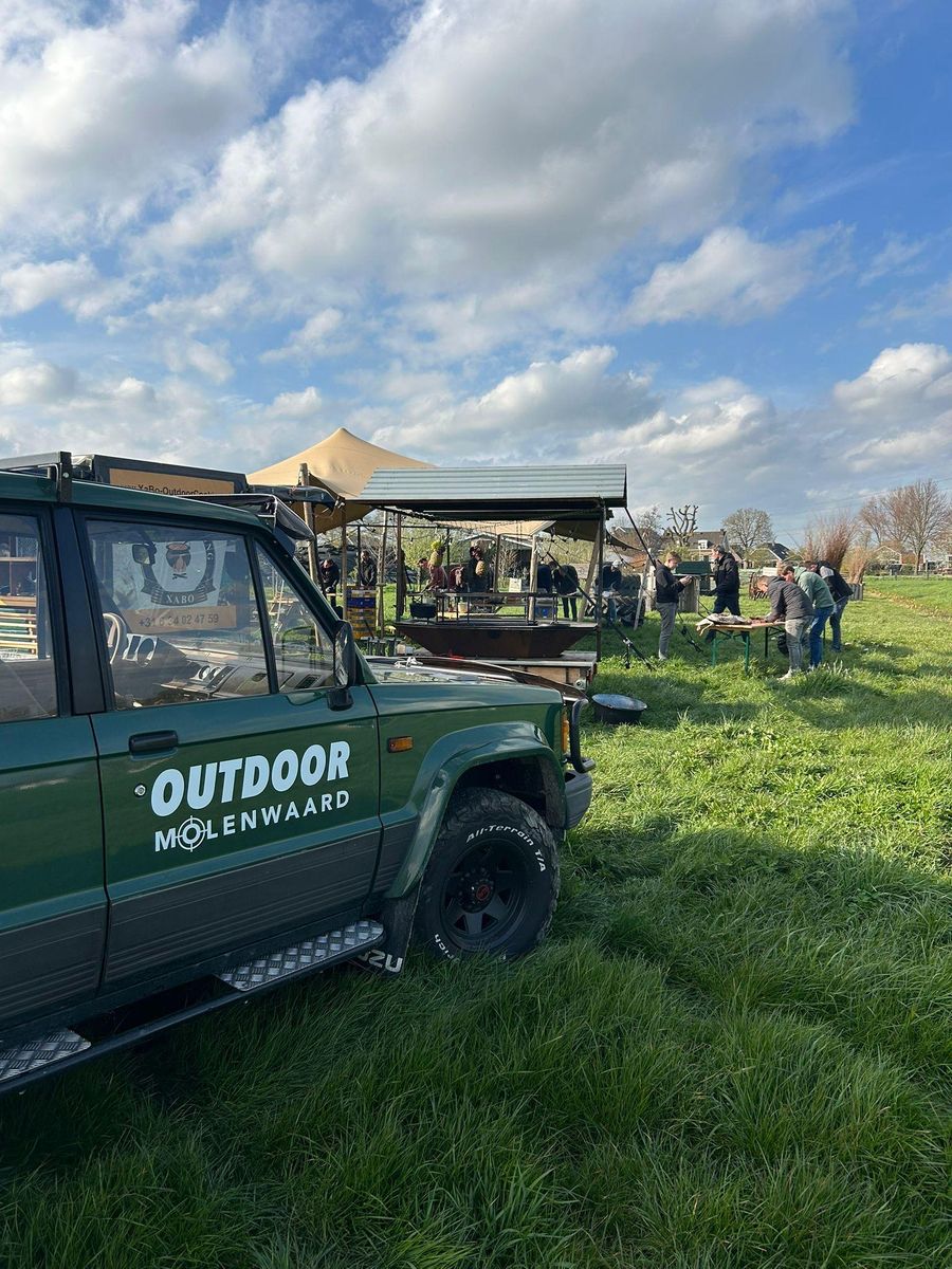 Defender met Outdoor Molenwaard-belettering op een evenement