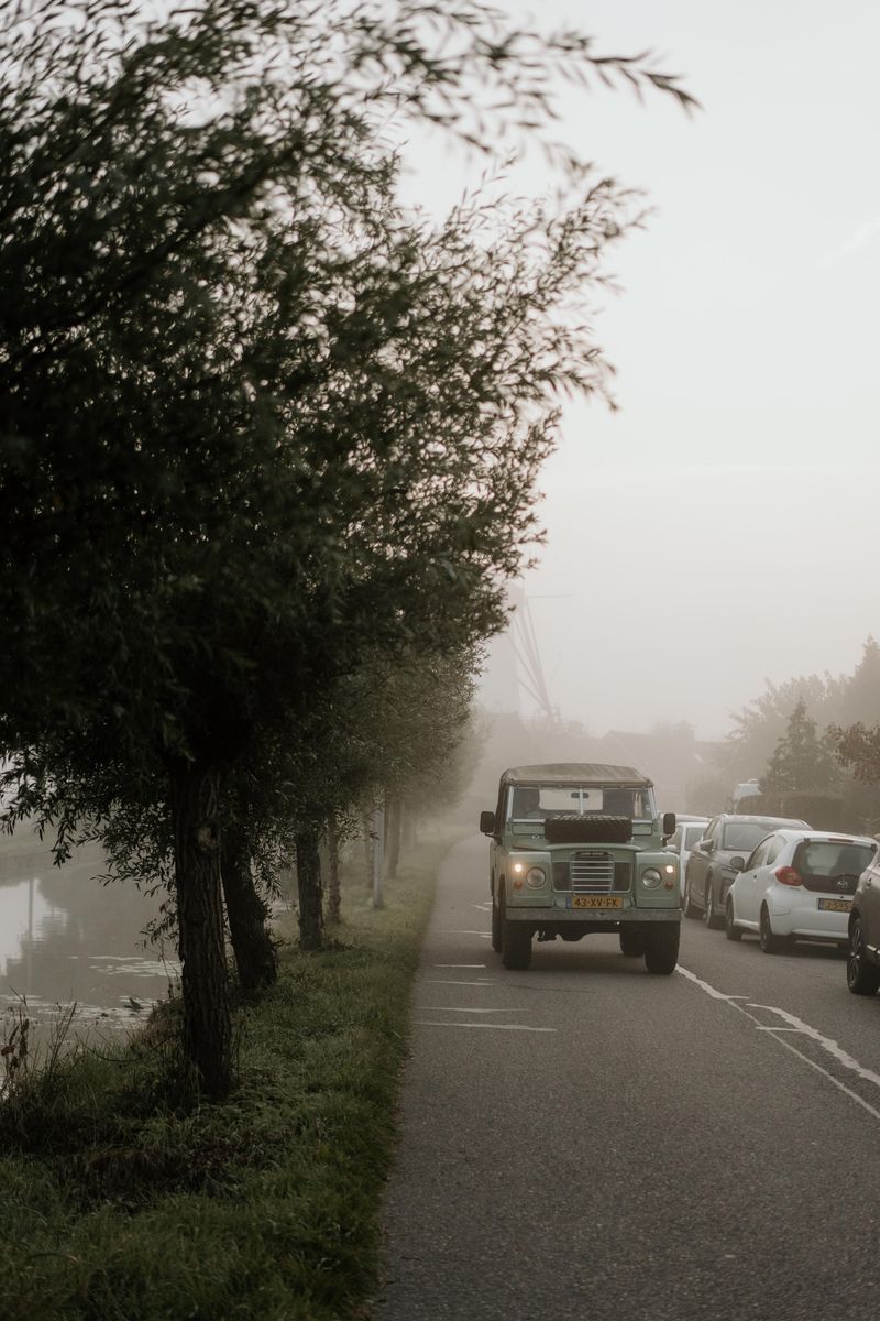 Land Rover op een mistige landweg tussen de bomen
