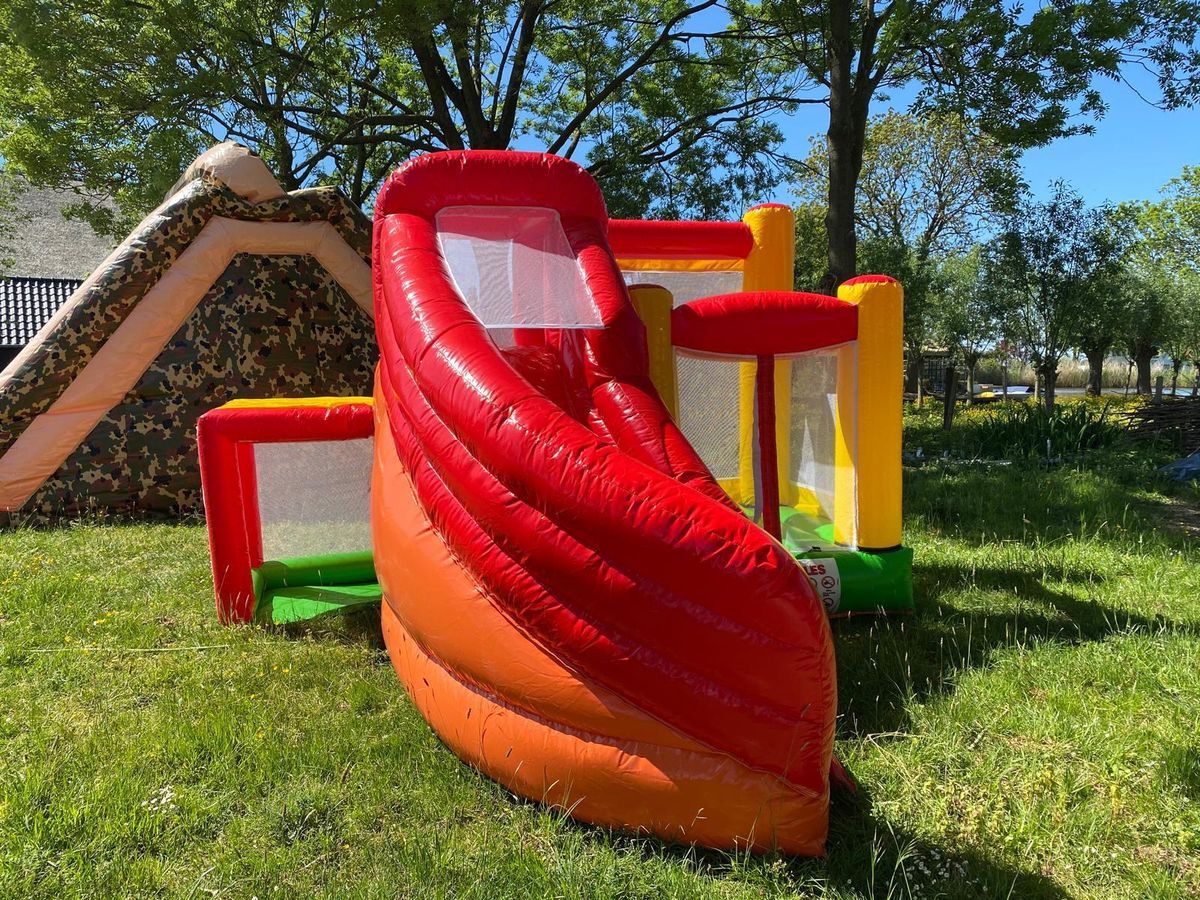 Springkussen met glijbaan in een tuin